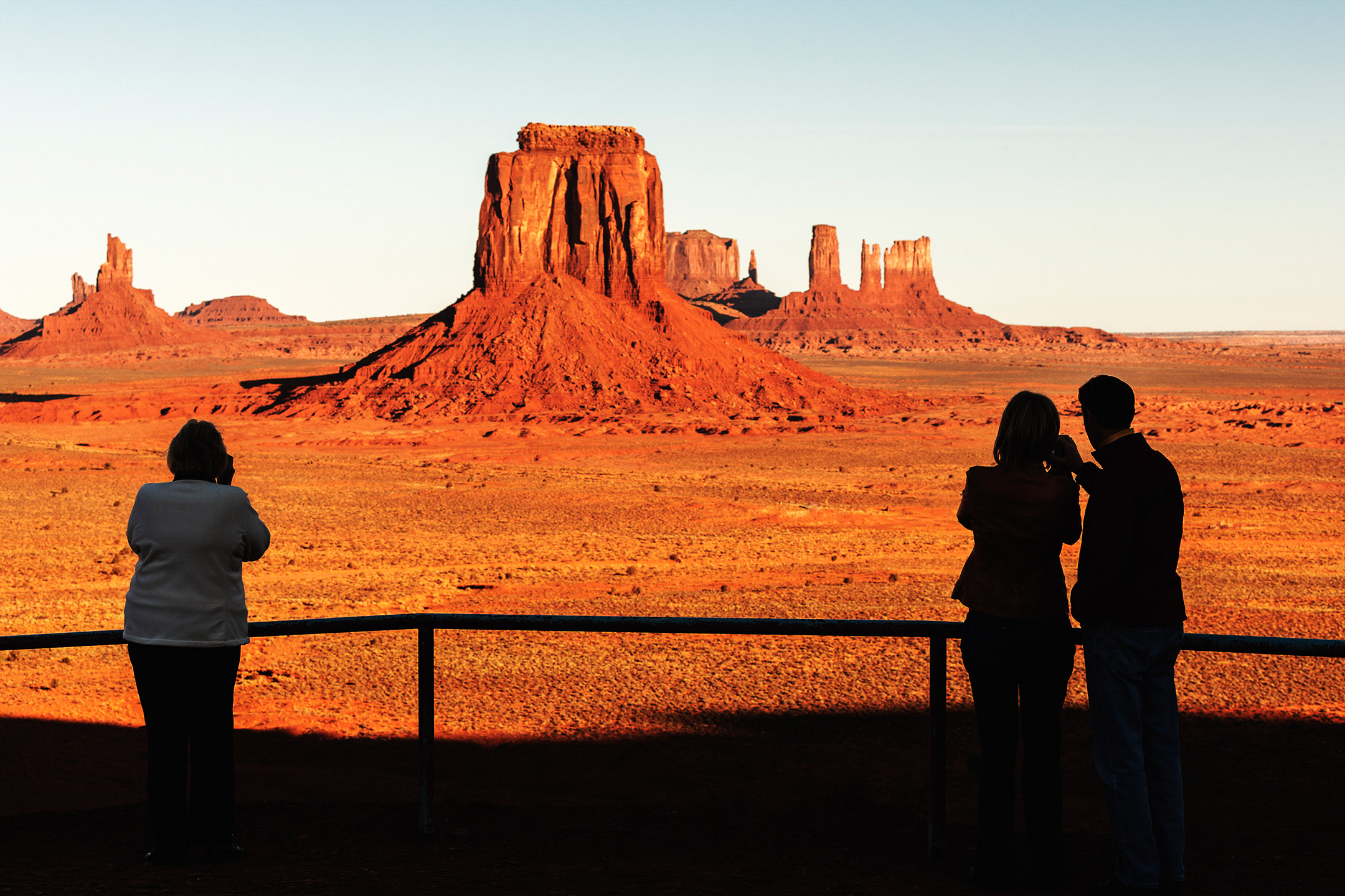 Silhouetted people enjoying a sunrise view of Monument Valley, Navajo County, Arizona.